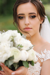 Close up portrait of gorgeous bride with bouquet