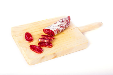 Spanish fuet, a dry sausage typical in Catalonia region, cut in slices on a wooden kitchen table