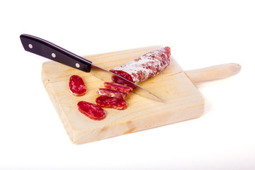 Spanish fuet, a dry sausage typical in Catalonia region, cut in slices on a wooden kitchen table