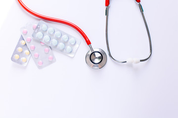 stethoscope for doctor checkup with pills on medical laboratory table