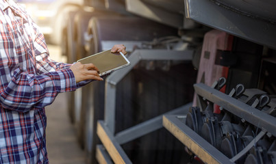 Truck drivers hand holding tablet checking the product list,Driver writing electronic log books,spot focus.