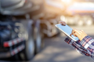 Truck drivers hand holding tablet checking the product list,Driver writing electronic log books,spot focus.
