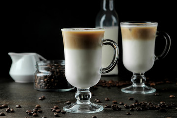 Ice latte or Iced coffee with milk and ice cubes in a glass beaker against a dark background. refreshing drink. summer drink.