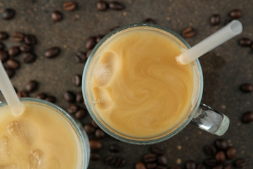 Ice latte or Iced coffee with milk and ice cubes in a glass beaker against a dark background. refreshing drink. summer drink. top view