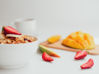 Summer breakfast berries, fruits and bowl with oatmeal. Cup of tea on white background