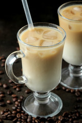 Ice latte or Iced coffee with milk and ice cubes in a glass beaker against a dark background. refreshing drink. summer drink.