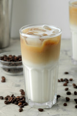 Ice latte or Iced coffee with milk and ice cubes in a glass beaker on a light background. refreshing drink. summer drink.