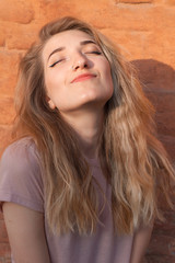Naklejka premium Portrait of the happy young woman near the red background