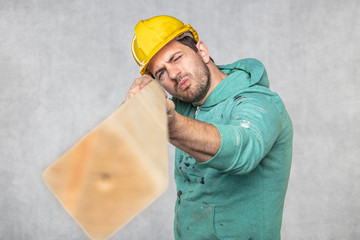 the construction worker holds a piece of board in his hands, the concept of choosing wood for construction