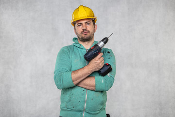 the construction worker holds an electric screwdriver in his hand, various situations