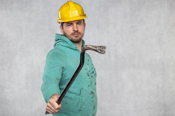 the construction worker holds a work tool in his hands, a crowbar