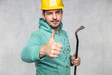 builder with a crowbar in his hand showing thumb up