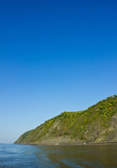 Fototapeta premium Hills and mountains with trees by the river. Side view.