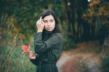 Female beauty portrait among golden foliage. Dreamy beautiful country girl with long natural black...