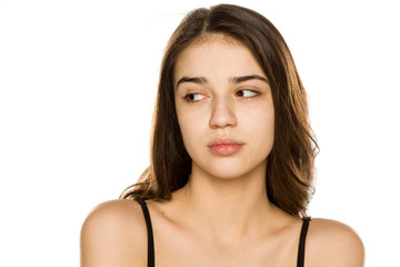 Young beautiful woman without makeup looking aside on white background