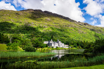 Kylemore Abbey with reflection in lake at the foot of a mountain. Connemara, Ireland - obrazy, fototapety, plakaty