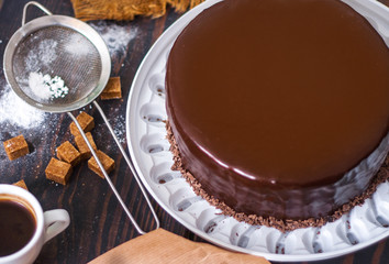 Glazed chocolate cake on the kitchen table.