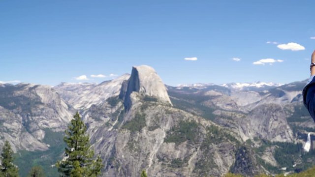 back view of japanese lady tourist on peak of high rocks in yosemite national park sightseeing half dome trail view with blue sky. Sport active life concept. relax woman backpacker on mountain top