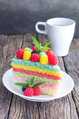 Waffle rainbow cake with raspberries and cup of coffee