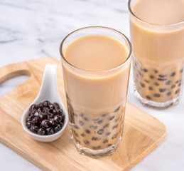 Popular Taiwan drink - Bubble milk tea with tapioca pearl ball in drinking glass on marble white...