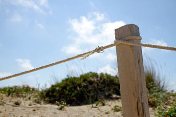 Wooden post with rope at the beach on a sunny day