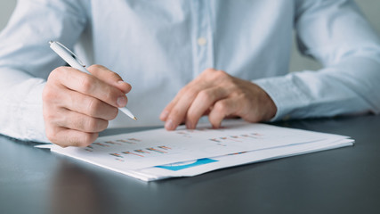 Business analysis. Cropped shot of man working with graphs and charts. Blur background.