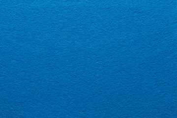 Blue felt texture abstract art background. Solid color construction paper surface. Empty space.