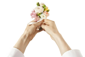 Bouquet of flowers in a man's hand. Little wedding bouquet on a white background. A man in a white shirt gives flowers from the first person.