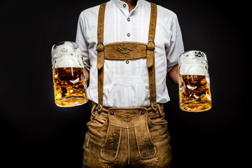 Man in traditional bavarian clothes holding mug of beer