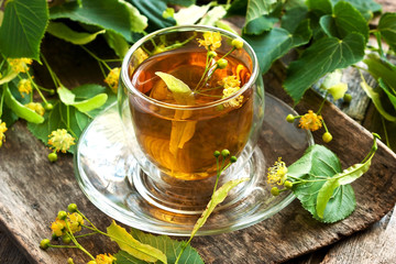 Linden flowers and cup of healthy tea, herbal medicine