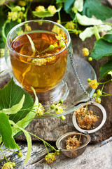 Herbal linden tea in glass cup, selective focus