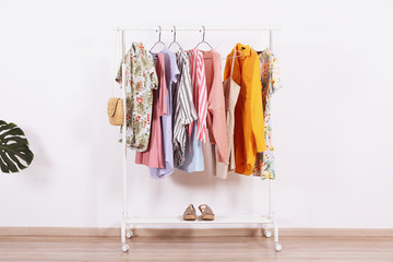 Women's hip clothing store interior concept. Row of different colorful female clothes hanging on...