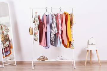 Women's hip clothing store interior concept. Row of different colorful female clothes hanging on...