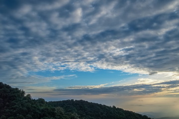 The eye of clouds shape heart, view center of Stratocumulus clouds shape heart above top hill with yellow sun light in the sky background, sunrise at Doi Inthanon, Chiang Mai, Thailand. (Real Nature)