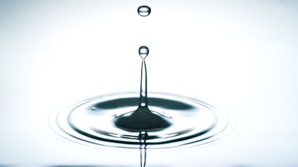 Close-up of a water drop falling on water surface