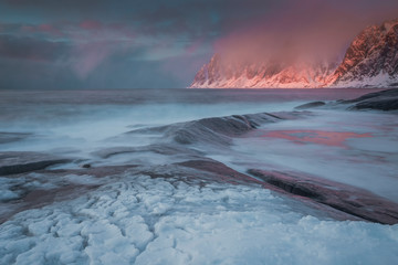 Amazing scenery on Lofoten Islands during sunset, mountains, snow and water in Norway