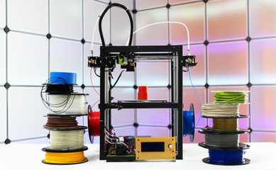 3d printer and plastic filament on color background