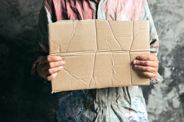 Male beggar hands seeking food or money with coins' tin from human kindness on the wooden floor at...