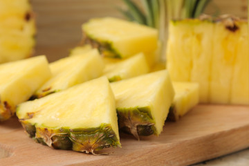 Fresh ripe pineapple halves and pineapple slices on a natural wooden background. summer. fruits.