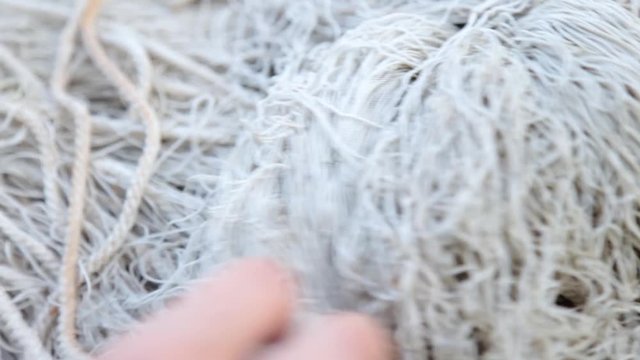 Close up Hands of Fishermans is sea unravels old fish network. concept fishing