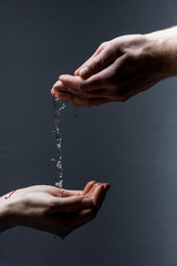 cropped view of man and woman with water drops on dark
