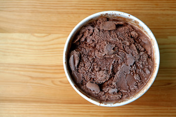 Top View of a Large Cup of Chocolate Ice Cream Isolated on Wooden Table