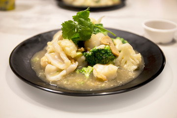 Fototapeta na wymiar Seafood with Broccoli and Cauliflower in garlic sauce
