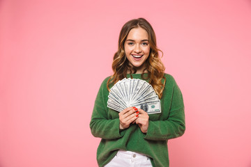 Happy blonde woman wearing in green sweater holding money