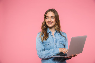 Pleased blonde woman wearing in denim shirt using laptop computer
