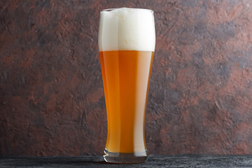 Glass of unfiltered wheat beer on brown concrete background