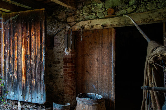 Old wooden door leading to stone barn