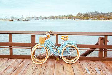 Santa Barbara romantisch concept op zee, strand, jachtclub panorama achtergrond. Twee retro fietsen staan op de pier van Santa Barbara, Californië, VS. Vintage filter met gedempte blauwgroen blauwe en oranje kleuren.