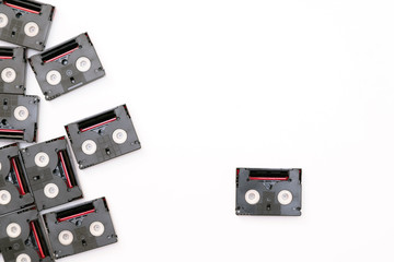 Vintage mini DV cassette tapes used for filming back in a day. Random pattern made of plastic video tapes on white background