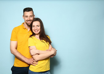 Happy young couple on color background